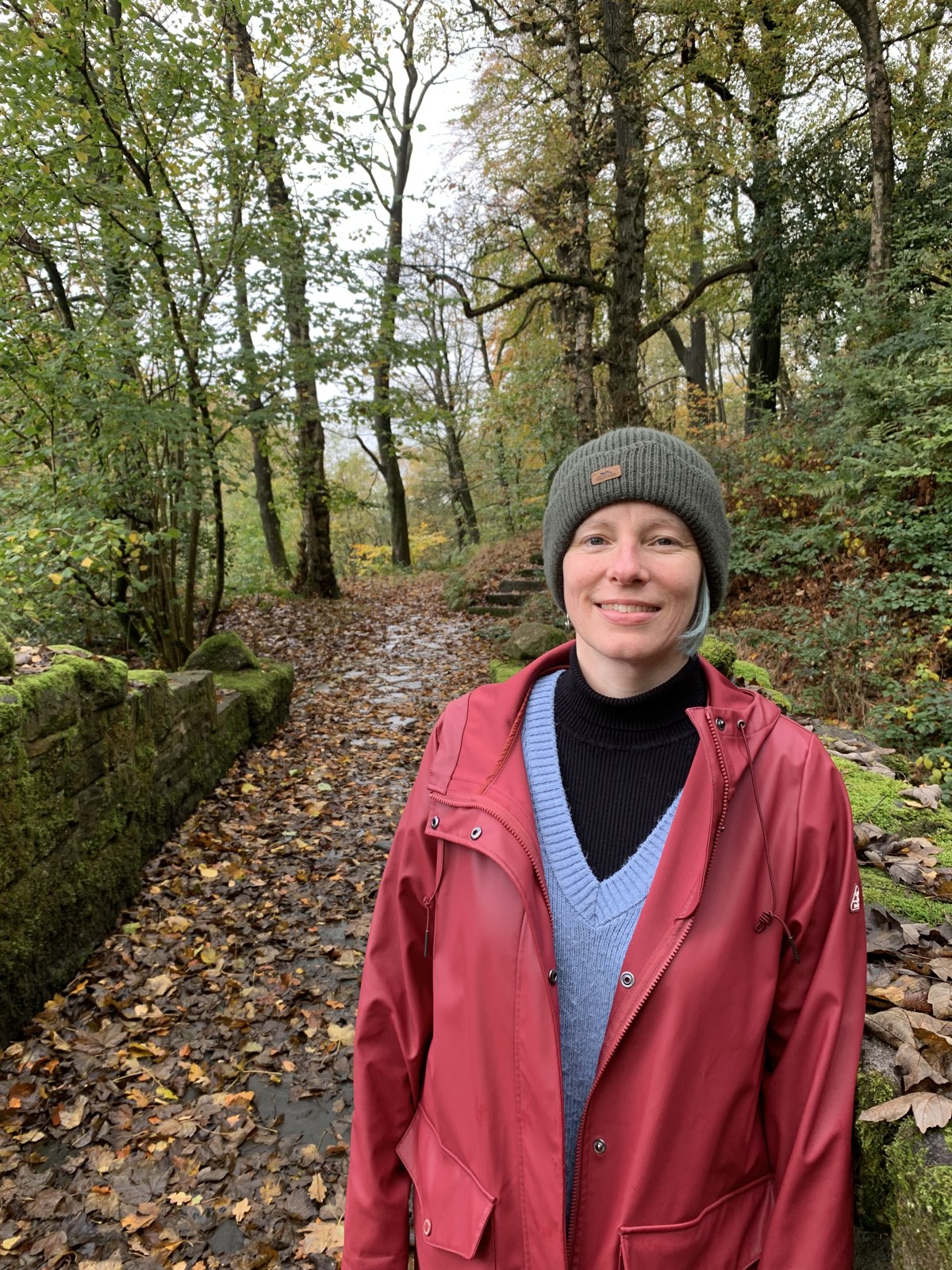 Diny in a red coat on a woodland path